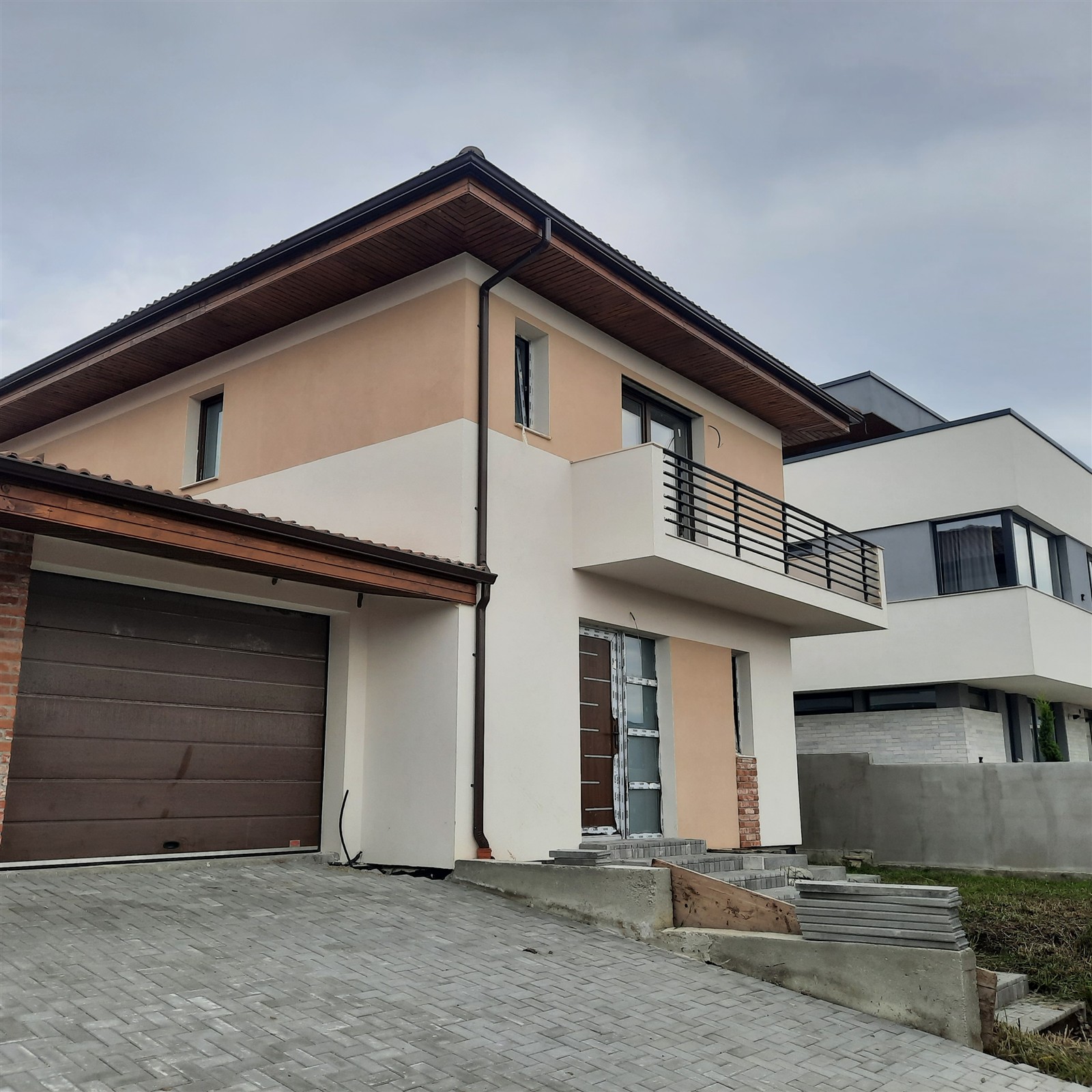 Casă cu etaj, balcon și garaj, cu fațada finisată